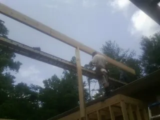 Carpenter setting a ridge beam over a new addition frame — Ice Dam Removal by Roofing Brothers in Vail